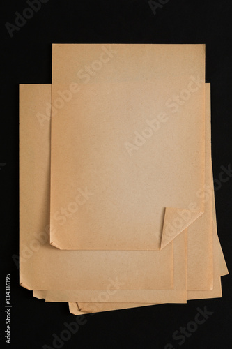 old craft paper sheets pile isolated on black background
