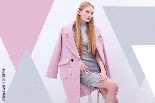 Young elegant woman in trendy pink coat.