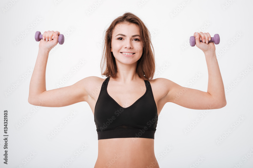 Cheerful young fitness lady make exercises with dumbbells Cheerful young fitness lady make exercises with dumbbells