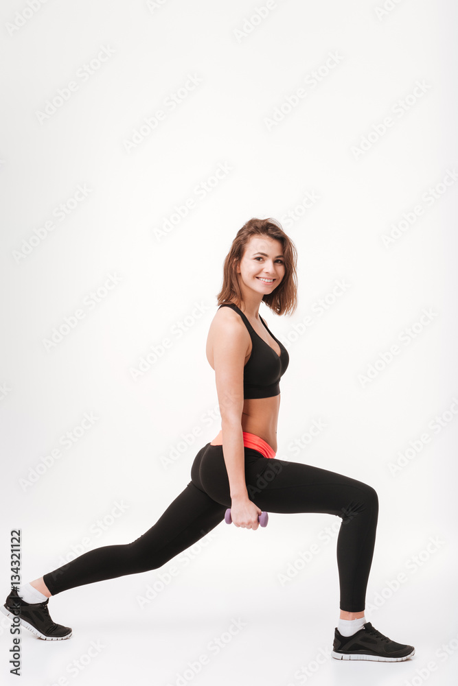 Happy young fitness lady make exercises with dumbbells