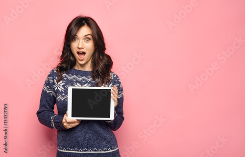 Surprised young woman using holding a digital tablet