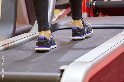 Fototapeta Naklejka Na Ścianę i Meble -  fitness woman legs on a treadmill in fitness sport club