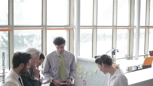 youngbusinessman making presentation of project to senior investior group of business people taking notes and make plans on white  flip board and tablet computer at startup office photo