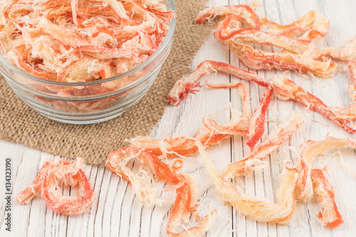 Fotografía Dried squid in a glass bowl on old wooden table.