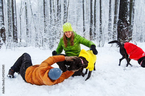 Activefamily walk the dog in the winter forest. photo