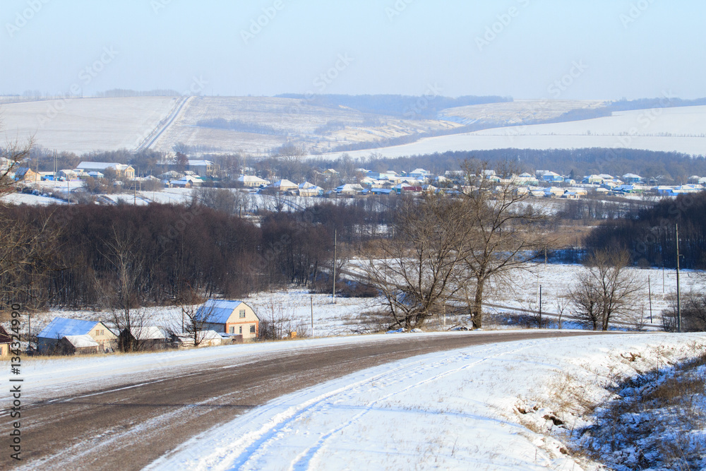 The village in winter. Houses, roads and trees covered with snow