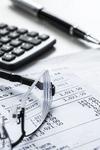 Fotografie Eyeglasses with calculator on table