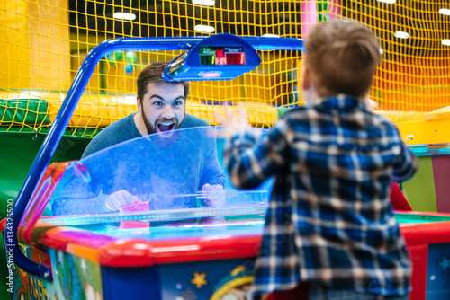 Canvas Print Father and son playing air hockey game at amusement park