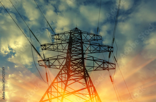 high voltage electric transmission tower at sunset.