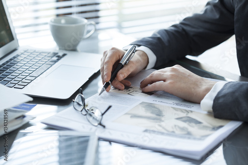 Fotografi Businesswoman reading newspaper on worktable