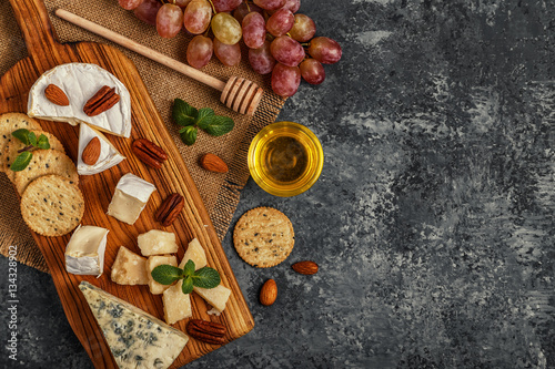 Assortment of cheese with wine  honey  nuts and grape.