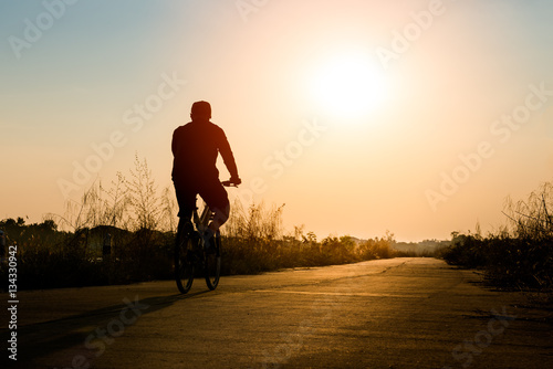Silhouette of cyclist on sunset background © songdech17