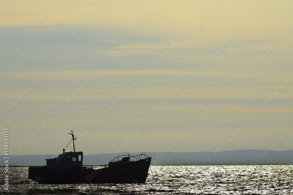 Beautiful view of the old fishing trawler at sunset
