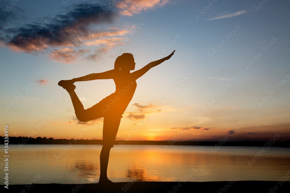 Silhouette woman with yoga posture  at sunset.