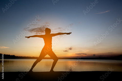 Silhouette woman with yoga posture  at sunset.