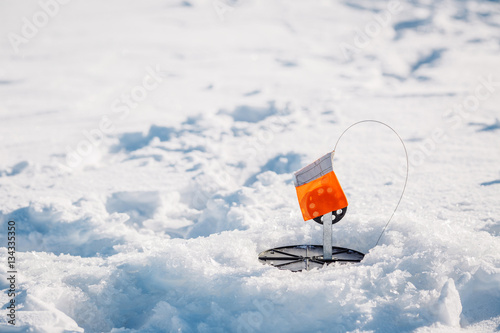 A ice fisherman's trap is set and ready to catch fish on a pond photo