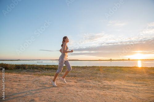 asian woman runing along the sea coast