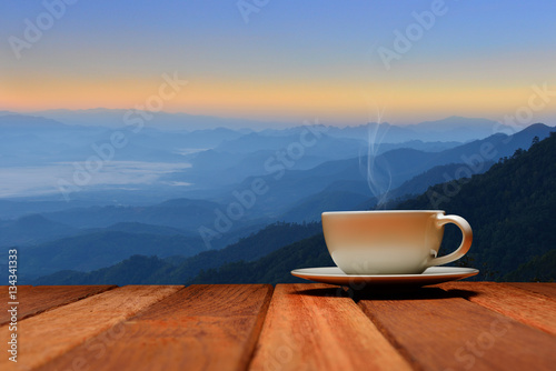 Morning cup of coffee or tea with mountain background at sunrise