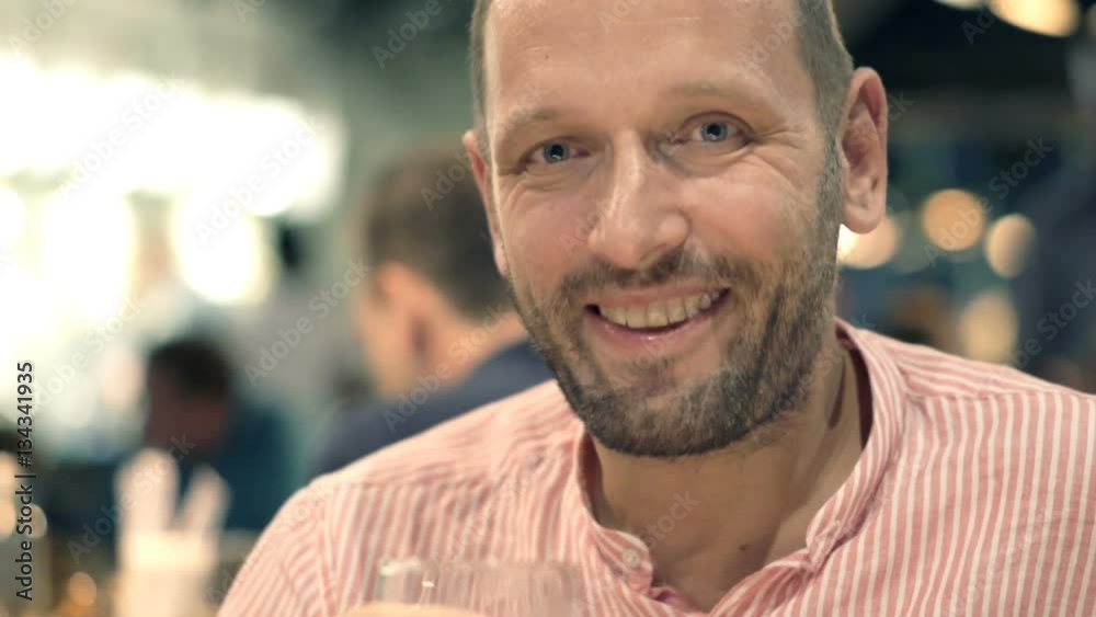 Happy man drinking beer in cafe at night
Happy man drinking beer in cafe at night