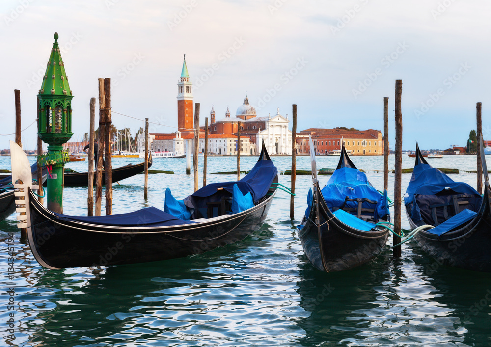 Venetian gondolas near the pier of San Marco in the background of the island of San Giorgio Maggiore. Venice, Italy
