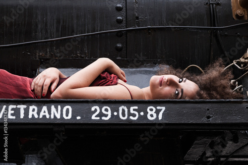 ragazza in abito da sera su un'antica locomotiva photo