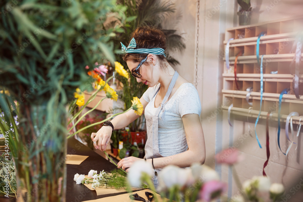 Φωτογραφία Woman florist making bouquet with white flowers in the shop