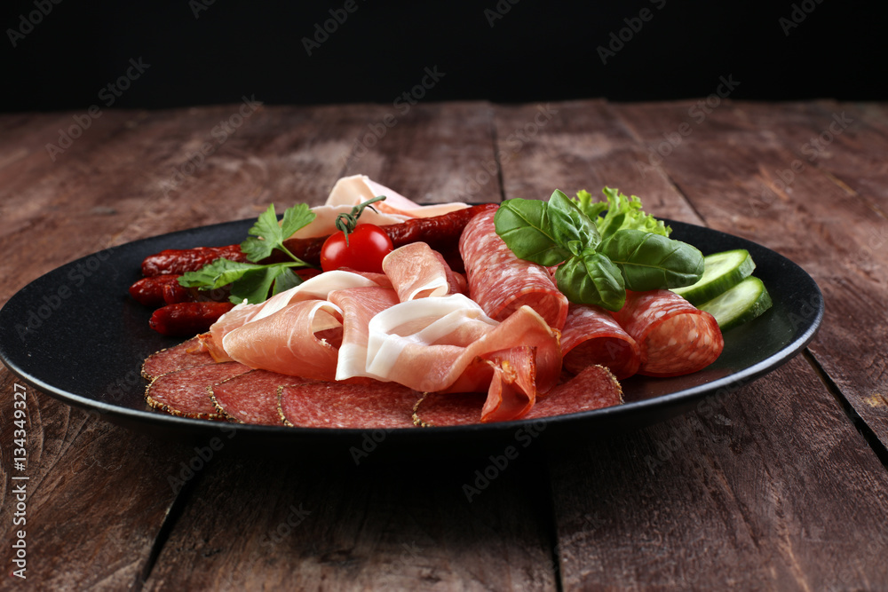 Food tray with delicious salami, pieces of sliced ham, sausage,