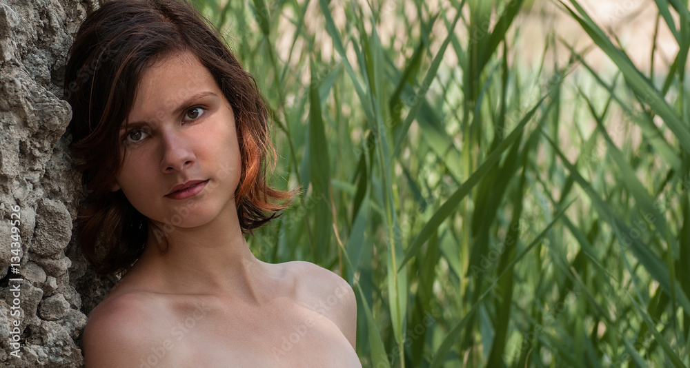 Portrait of teen brunette against rock with water cane