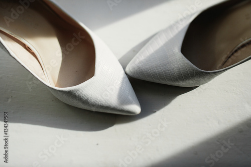 Wedding shoes stand nose by nose on white floor