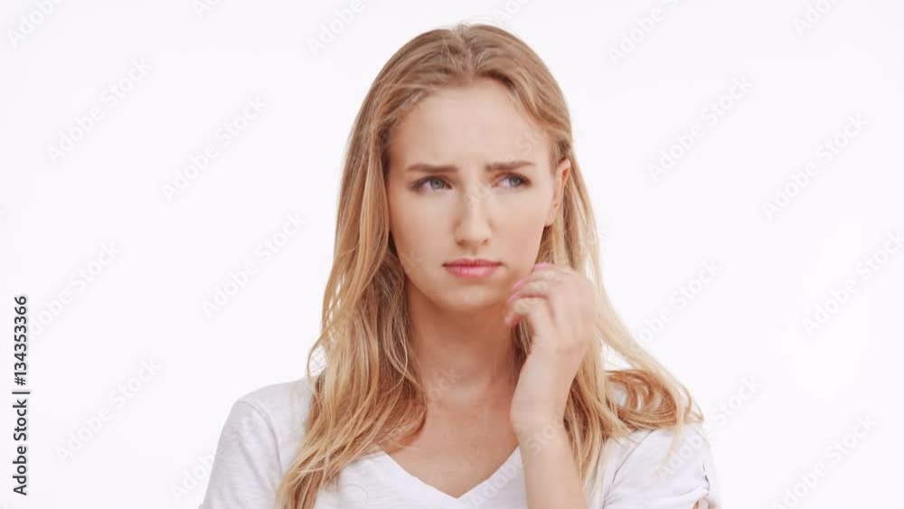 Sad young beautiful Caucasian blonde girl trying not to cry on white background Sad young beautiful Caucasian blonde girl trying not to cry on white background