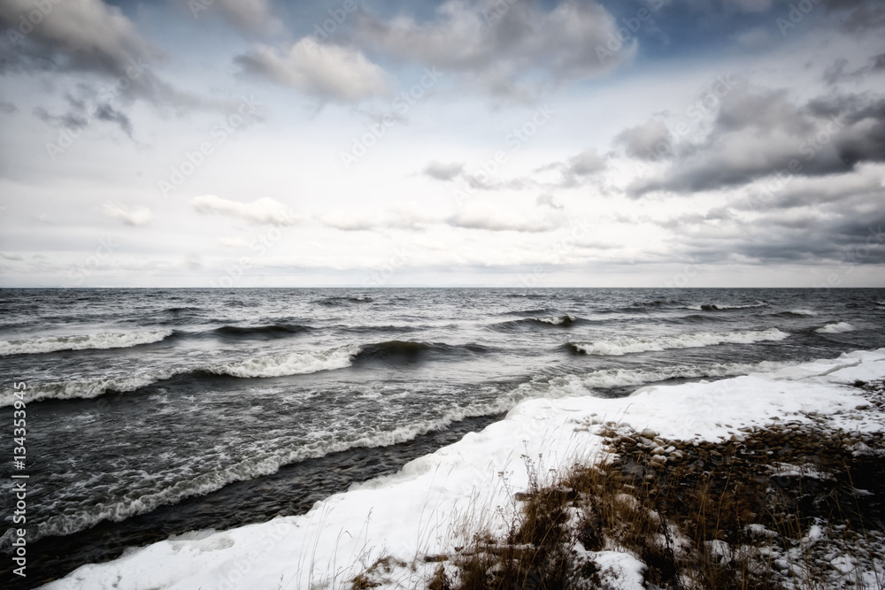 First snow on Lake Baikal, on background waves and colorful landskape