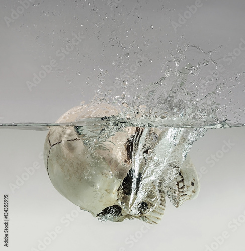 Drowning human skull in the water photo