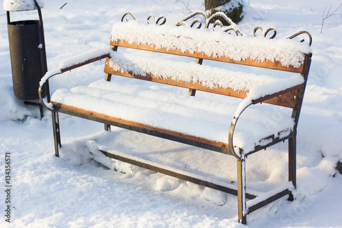 Wooden bench covered by sno...