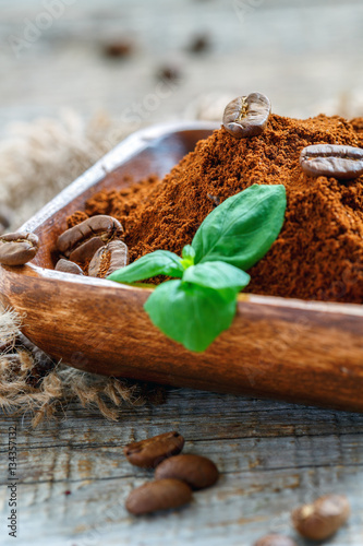 Bowl with ground coffee and mint closeup.