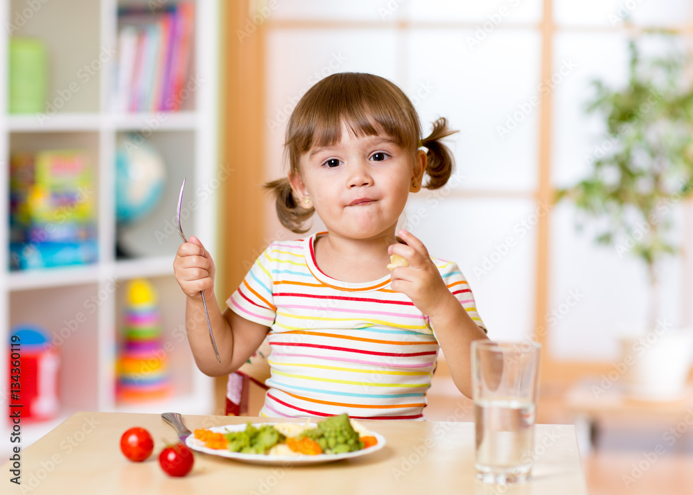 Funny little girl has dinner in kindergarten Funny little girl has dinner in kindergarten