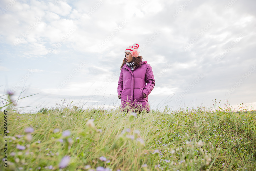 Young woman was playing in a field of flowers in the winter air. Young woman was playing in a field of flowers in the winter air.