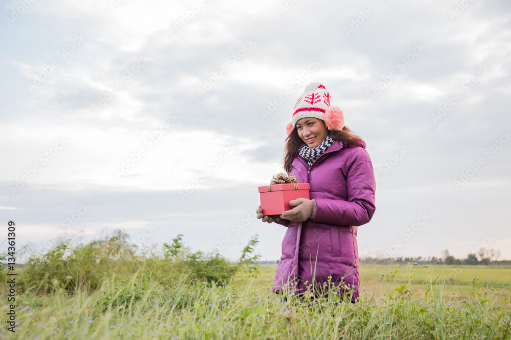 Happy young woman with gift in hands. Christmas and winter conce Happy young woman with gift in hands. Christmas and winter conce