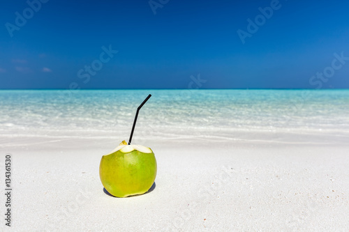 Fresh green coconut, ready to drink. Tropical beach in Maldives