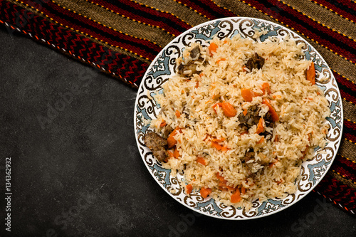 Pilaf on plate with oriental ornament. Central-Asian cuisine - Plov. Top view.