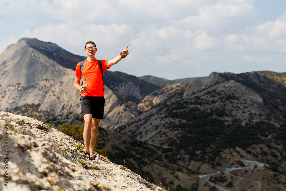 Traveler on rock in summer