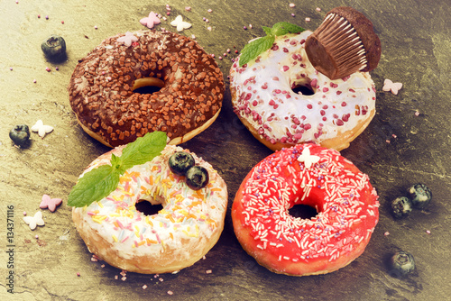 Donuts glazed with various sprinkles. Sweet food background