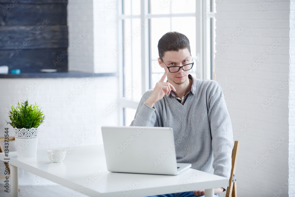 Portrait of young businessman in office with big window. Portrait of young businessman in office with big window.