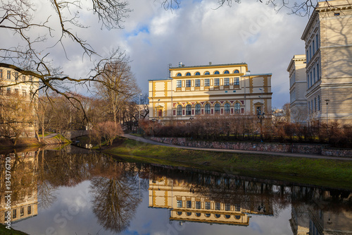 Canal in park and beautiful reflection of buildings in water. Riga old town.