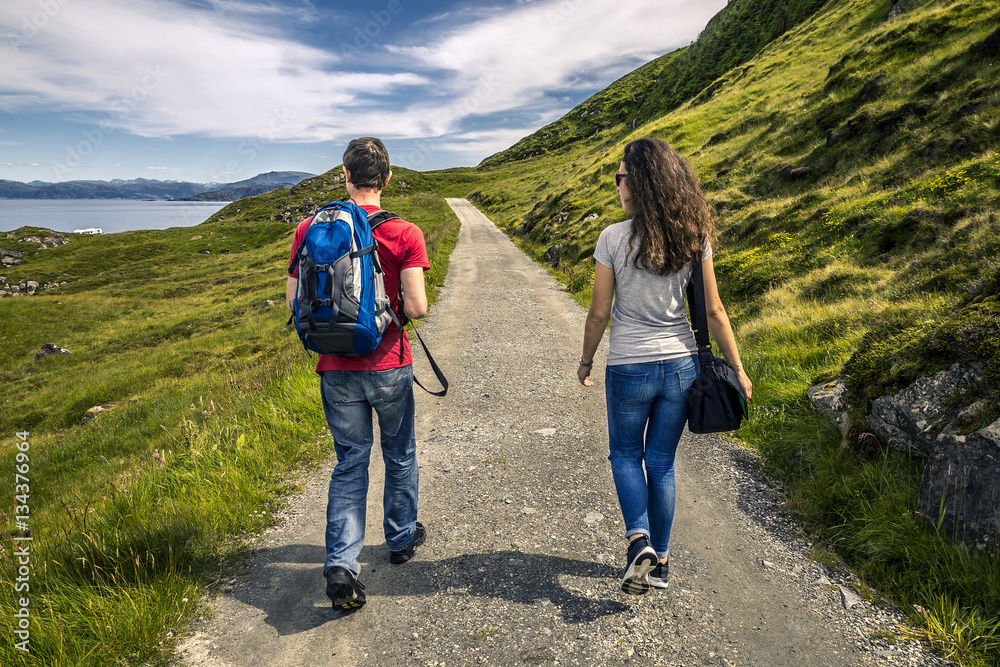 Two young people walking along the countryside road, Norway