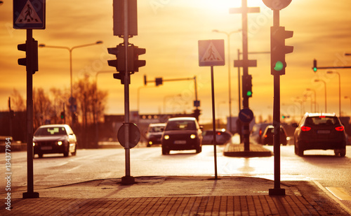 Cars moving on the road in city in early morning. View to the traffic with trafficlights and transport photo
