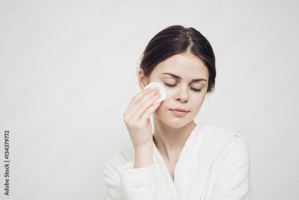 beautiful woman wiping her face with a cotton pad beautiful woman wiping her face with a cotton pad