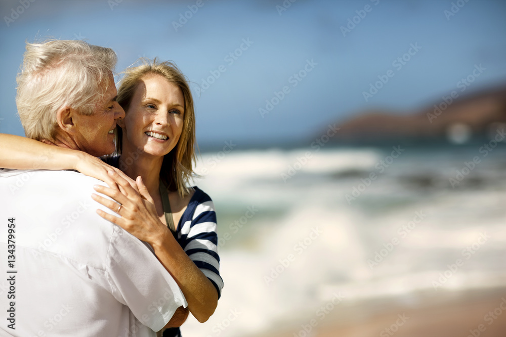 Smiling couple hugging each other on a beach. Smiling couple hugging each other on a beach.