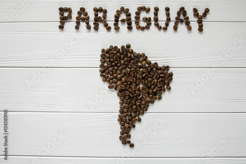 Map of the Paraguay made of roasted coffee beans laying on white wooden textured background. Space for text