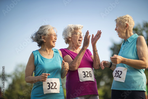 Three elderly friends have fun at an athletics event. photo