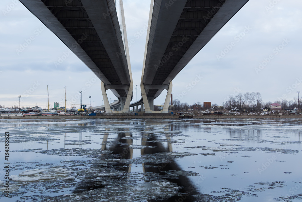 The reflection on the concrete bridge in the winter river